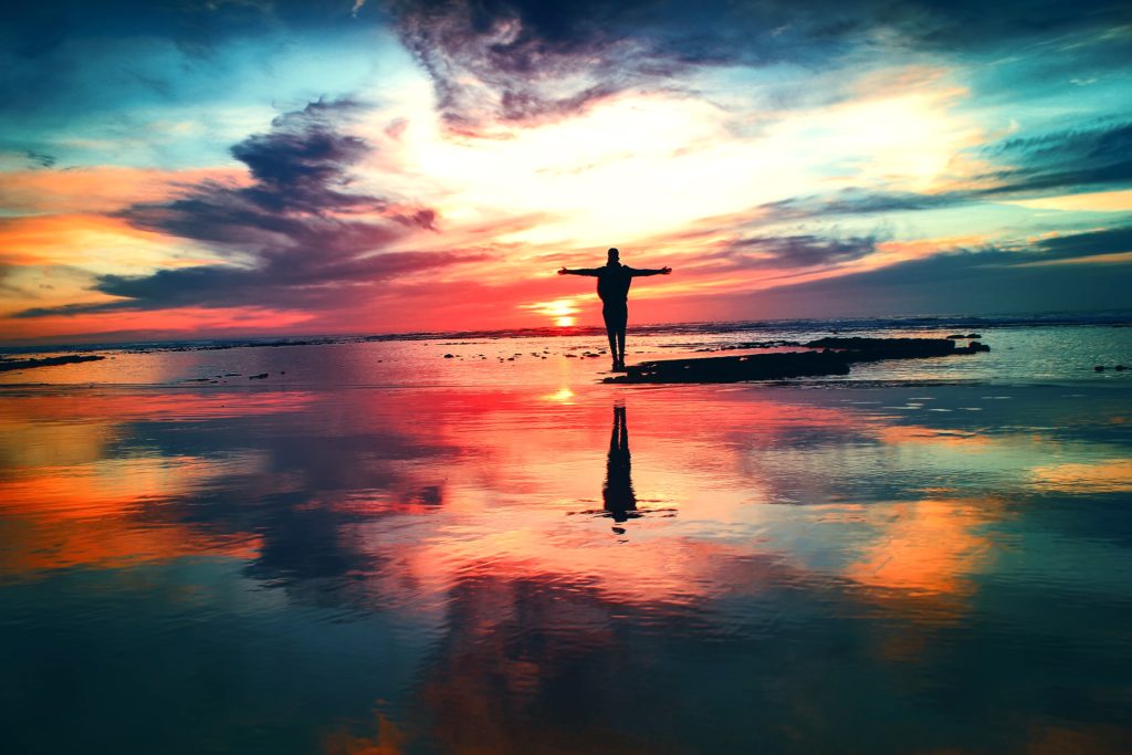 man watching the sunset during low tide