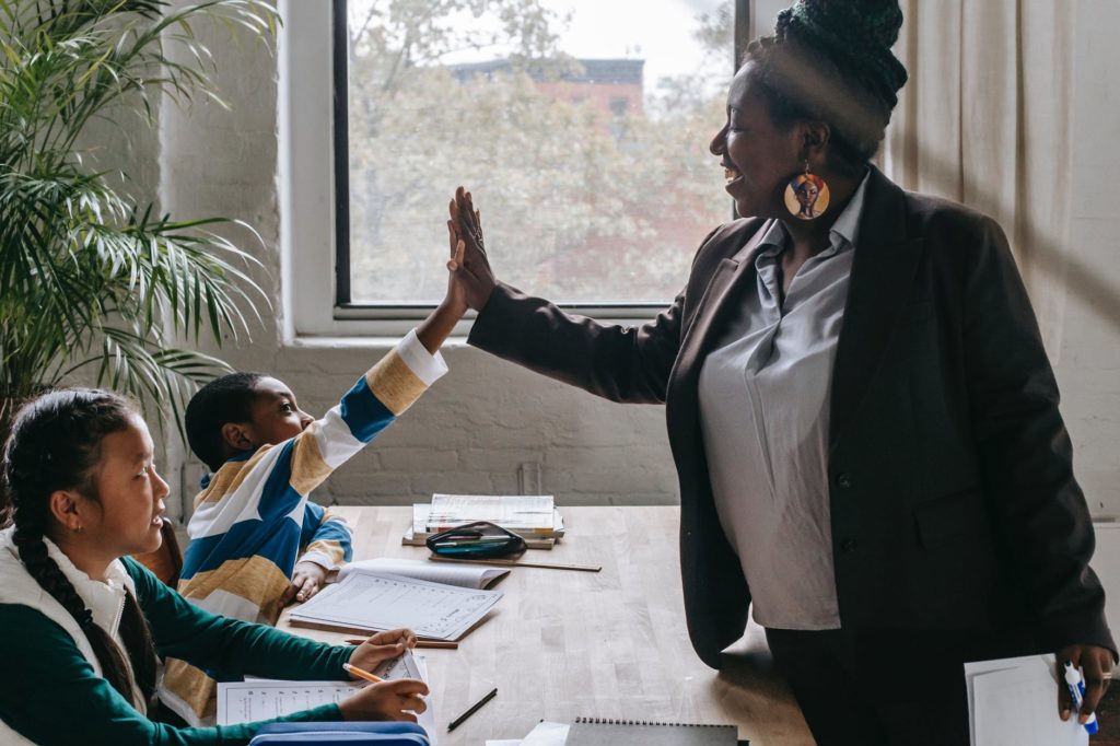 a teacher gives a high five a student - Best side hustles in 2020